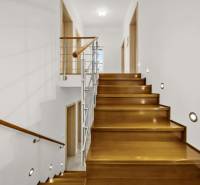 Lépcső fa dekorációval és korláttal egy családi házban.