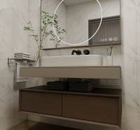 Fürdőszoba egy háromszobás lakásban, fa mintázatú padlóval, tükörrel és mosdókagylóval.