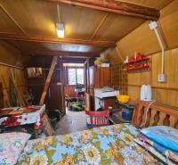 A faház belső tere fa dekorációval, bútorokkal és konyhai eszközökkel.