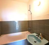 Fürdőszoba zöld csempékkel, káddal és mosdóval egy 4 szobás lakásban.