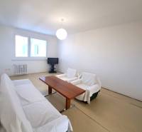 Nappali asztallal és kanapéval egy 4 szobás lakásban, fa dekorációjú padlóval.