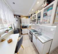 Konyha egy kétszobás lakásban fa dekor padlóval, világos megvilágítással és modern felszereléssel.