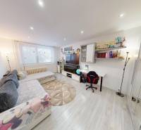 Nappali egy kétszobás lakásban kényelmes kanapéval és fa dekorációjú padlóval.