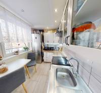 Konyha egy kétszobás lakásban étkező sarokkal, szekrényekkel és nagy ablakkal.