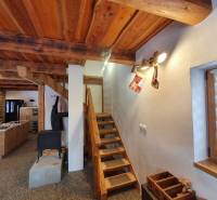 Fából készült lépcsők egy faházban, fa dekoros padlóval, karácsonyi díszekkel.