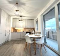 Konyha egy háromszobás lakásban fa dekor padlóval és erkéllyel.