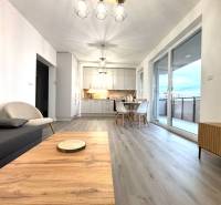 Nappali fa mintás padlóval és étkezőasztallal egy háromszobás lakásban.