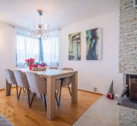 Ebédlő egy családi házban, fa dekorációjú padlóval, kandallóval és fali művészettel.