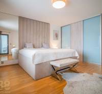 Hálószoba családi házban, ággyal, fa dekorációjú padlóval és szőrmés szőnyeggel.