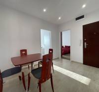 Ebédlőasztal és székek a háromszobás lakás előszobájában, járólappal.