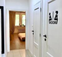 Folyosó egy kétszobás lakásban fehér falakkal és csempével.