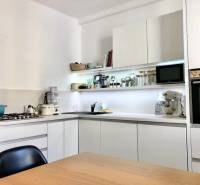 Konyha egy kétszobás lakásban fehér szekrényekkel és beépített készülékekkel.