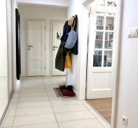 Folyosó egy kétszobás lakásban beépített szekrénnyel és csempével.