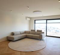 Nappali egy 4 szobás lakásban kanapéval, ablakkal és fa dekorációjú padlóval.