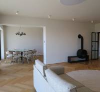 Nappali egy négy szobás lakásban kandallóval és fa dekorációjú padlóval.