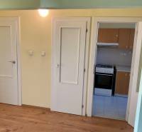 3 szobás lakás belső tere fa dekor padlóval és konyhabútorral.