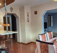 Ebédlő egy családi házban fa elemekkel, asztallal és székekkel, világos belső tér.