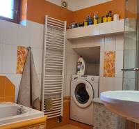 Fürdőszoba családi házban mosógéppel, zuhanyzóval, káddal és színes csempékkel.