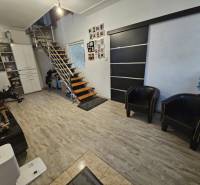 Családi ház belső tere modern lépcsőkkel és fa dekorációjú padlóval.