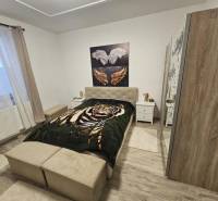 Hálószoba ággyal, szekrénnyel és fa dekorációjú padlóval egy családi házban.