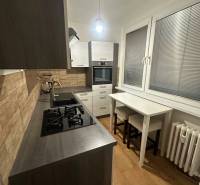 Konyha egy kétszobás lakásban, fa dekorációjú padlóval és gáz tűzhellyel.