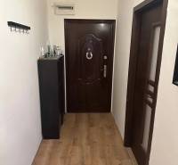 Előszoba fa mintázatú padlóval egy kétszobás lakásban.