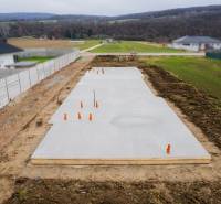 Egy családi ház alapjai Sokolovcén, vidéki tájjal és szomszédos házakkal körülvéve.