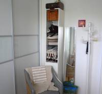 Kényelmes fotel fa dekorációjú padlóval egy háromszobás lakásban.