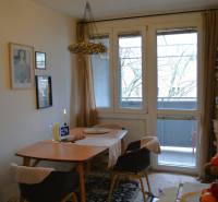 Étkező sarok egy háromszobás lakásban szőnyegmintával és üvegezett ajtókkal az erkélyre.