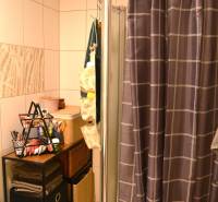 Fürdőszoba áthidalással és tárolóhelyekkel egy háromszobás lakásban.