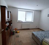 Szoba családi házban ággyal, bútorokkal és fa dekorációjú padlóval.