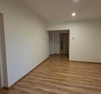 Családi ház belső tere fehér falakkal és fa dekorációjú padlóval.