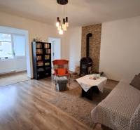 Szoba családi házban kandallóval, kanapéval, könyvtárral és fa dekorációjú padlóval.