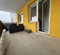 Erkély egy kétszobás lakásban Zsolnán, burkolt padlóval és kerti bútorokkal.