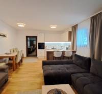 Nappali kétszobás lakásban konyhával, étkezőasztallal és fa dekorációjú padlóval.