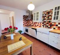 Konyha egy 4 szobás lakásban színes csempékkel és fa dekorációval az asztalon.