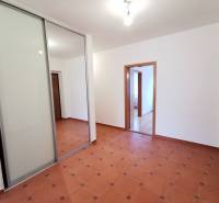 Folyosó egy 4 szobás lakásban csempével és beépített szekrénnyel tolóajtókkal.