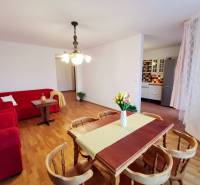 Nappali egy négy szobás lakásban piros kanapékkal és fa mintázatú padlóval.