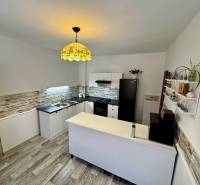 Konyha egy családi házban fa dekor padlóval, világítással és dekoratív burkolatokkal.