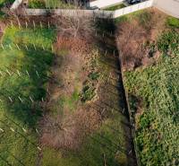 Kerítéssel körülvett telek Felsőszeliben, szétszórt fákkal, lakóövezetben.