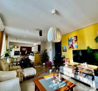 Nappali sárga fallal és fa dekorációjú padlóval egy 4 szobás lakásban.