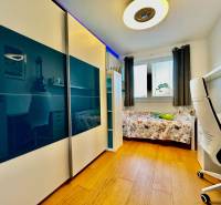 Gyerekszoba egy 4 szobás lakásban ággyal, íróasztallal és ruhásszekrénnyel.