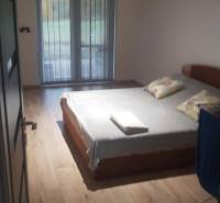 Hálószoba családi házban, ággyal és fa dekorációjú padlóval.