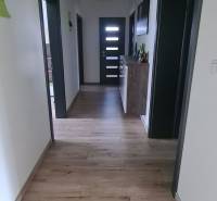 Folyosó egy családi házban fa dekorú padlóval és zöld részletekkel a mennyezeten.