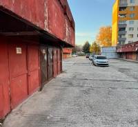 Garázsok a Bebravska utcában, Pozsony-Vrakuňa, lakóházak és autók mellett.