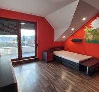 Gyerekszoba dinoszaurusz mintás fallal és fa dekorációjú padlóval egy családi házban.