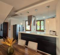 Konyha étkezőasztallal és fa dekorációjú padlóval egy családi házban.