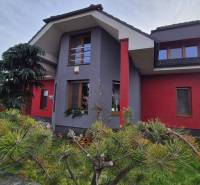 Családi ház a Krakkóvany-i Szeles utcában, fákkal és rendezett kerttel körülvéve.