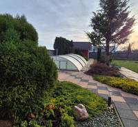 Kert a családi ház mellett a Krakovany-i Veterná utcában, medencefedéssel.