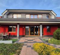 Családi ház Krakkóváron a Szeles utcában, piros homlokzattal és kerttel.